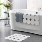 Rubber shower mat hanging to dry after use with strong suction cups